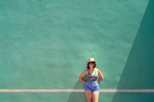 a Hispanic female from Mexico with summer clothes in front of the blue wall