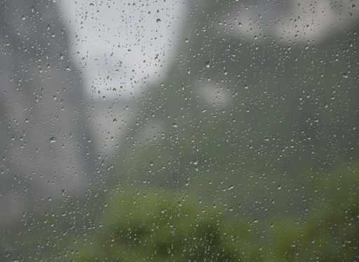 A closeup shot of a wet glass surface with droplets of water after rain