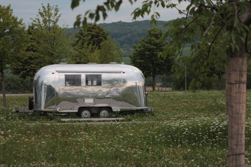 A vintage Airstream Caravan in a green park