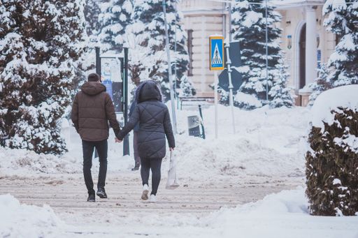 A couple walking over a crosswalk during winter in Radauti, Romania