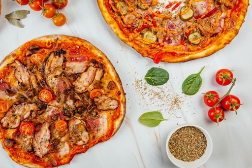 A top view of various tasty pizzas and spices