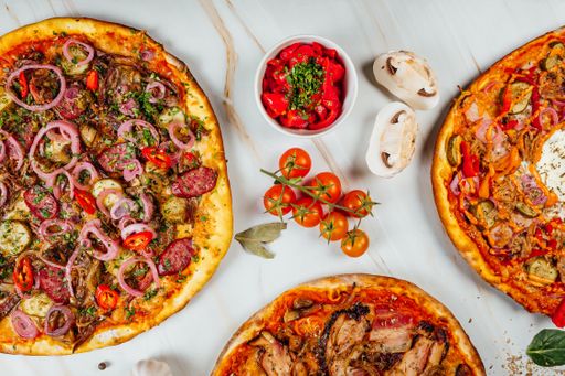 A top view of various tasty pizzas and spices