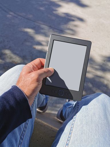A man sitting and reading outdoors on a sunny day