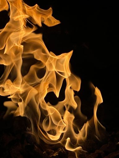 A vertical shot of a raging fire on a black background