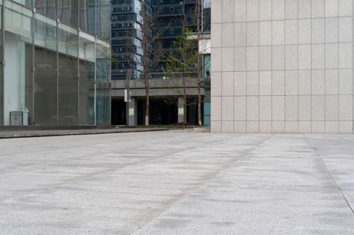 empty concrete ground floor with modern office building exterior in downtown.