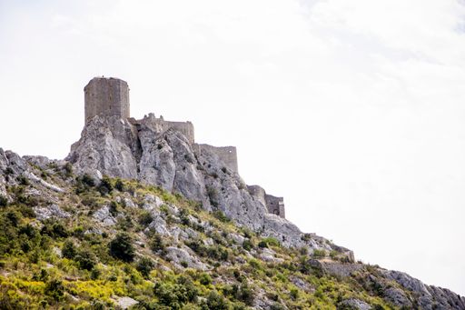 A majestic mountain landscape featuring a rustic ancient structure perched atop the summit