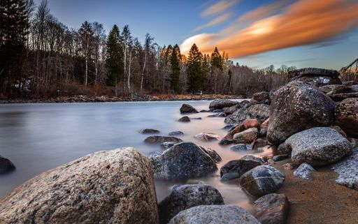 A long exposure shot of a beautiful sunset over the rocky Lagan River