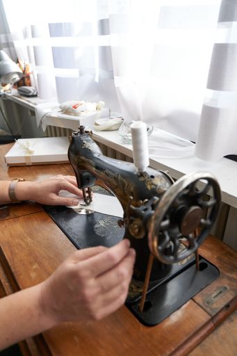 A hands of a woman working with a sewing machine in close up.