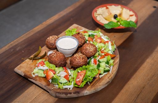 Falafel plate with vegetables salad and sauce on the table.