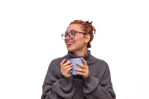 A young woman in eyeglasses holding a mug isolated on white background
