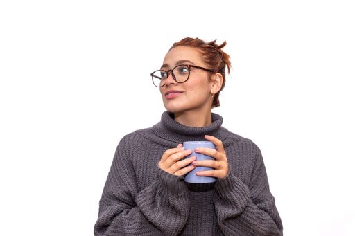 relaxed young redhead woman drinking from a cup