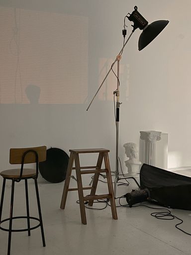 This image features a studio workspace with window light and professional lighting equipment