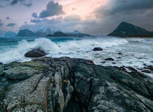 A majestic view of a rocky coastline with waves crashing against the shoreline