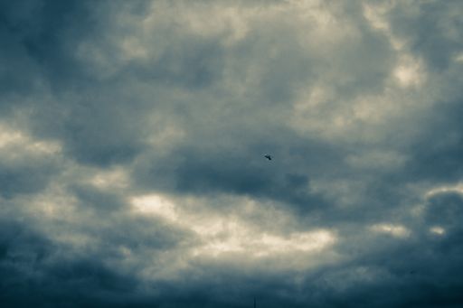 A low angle view of the helicopter flying above a cloudy sky during the evening