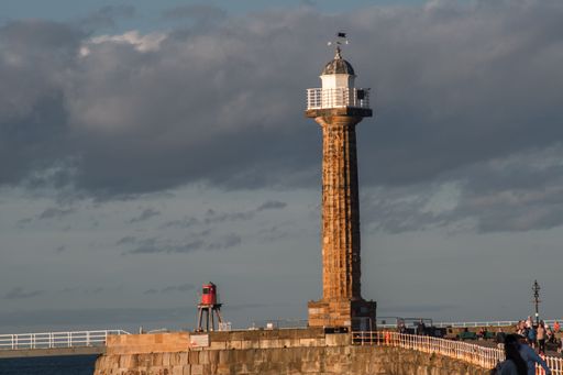 A picturesque illustration of the historic Whitby lighthouse near a body of water