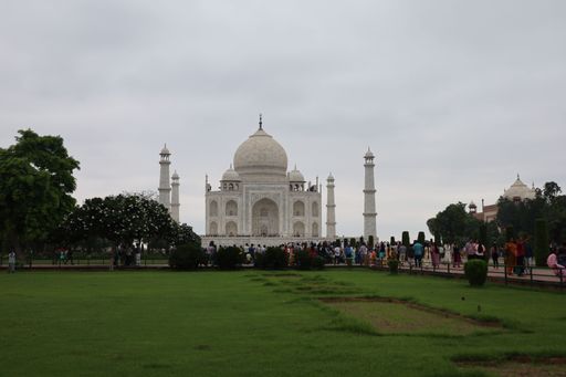 A beautiful shot of the historic Taj Mahal and grounds with a crowd of tourists