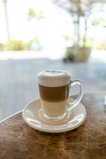 A vertical shot of a cup of hot latte on the table