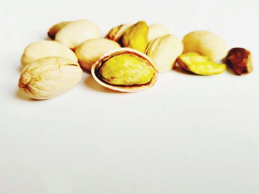 A selective focus shot of pistachios on a white background