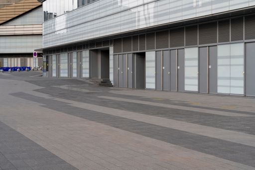 Empty sidewalk with large commercial building in the background