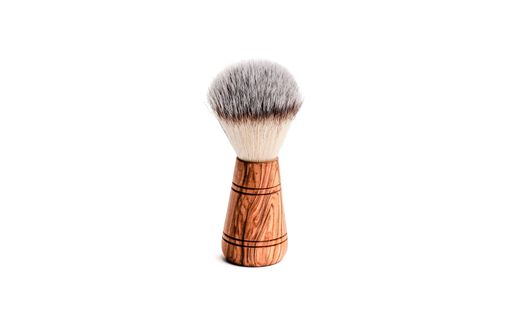 A close-up image of a classic wood-handled shaving brush on a white background