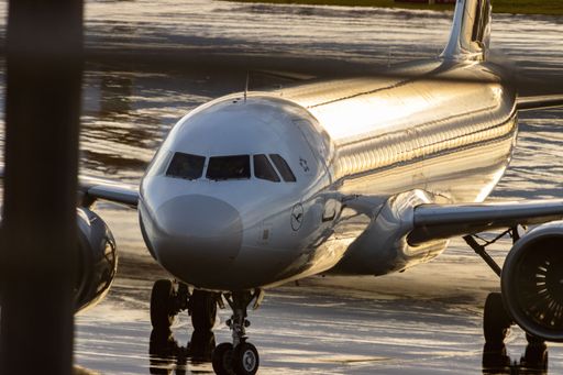 An aerial view of a large commercial airliner parked at the gate of an airport, ready for takeoff