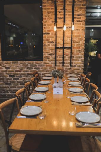 An elegant table setting with white plates and glasses on a wooden table in the restaurant