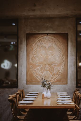 An elegant table setting with white plates and glasses on a wooden table in the restaurant