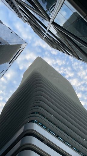 Low angle view of contemporary high-rise buildings against a backdrop of cloudy sky
