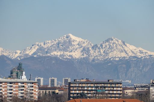 A scenic view of buildings in a town against a snowy mountain landscape background