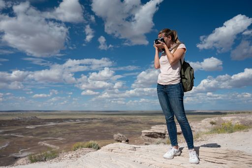 Portrait of a young girl with a backpack taking photos in the Petrified Forest National Park