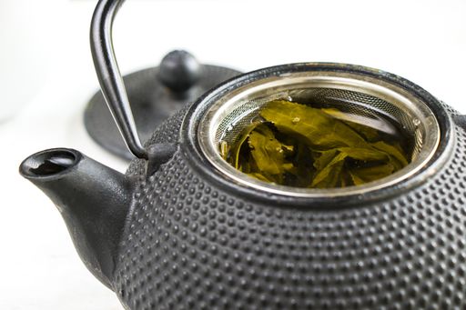 A herbal tea, iron teapot and cup of tea on the white background, chinese traditional tea serving
