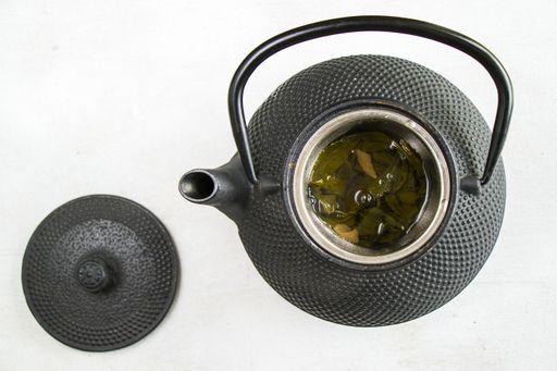 A top down closeup of herbal tea in an iron teapot - traditional Chinese tea serving