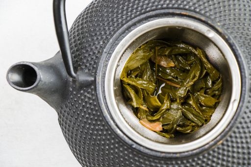 A top down closeup of herbal tea in an iron teapot - traditional Chinese tea serving