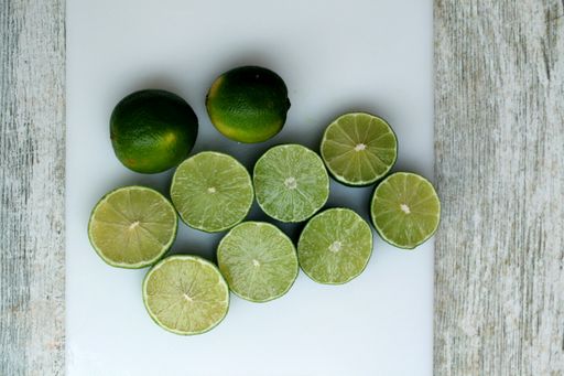 A vertical shot of fresh lemons and limes on a wooden surface
