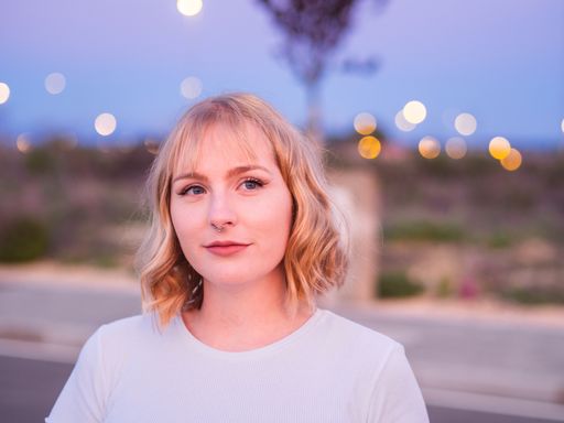 A shallow focus shot of a beautiful blonde caucasian female with a white shirt