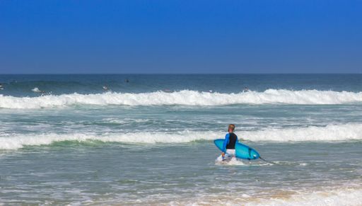 A surfer at the beach on a sunny day