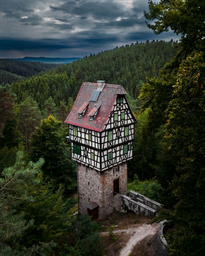 An aerial view of Herzogstuhl, Historical landmark situated among lush, dark green foliage in a forested area