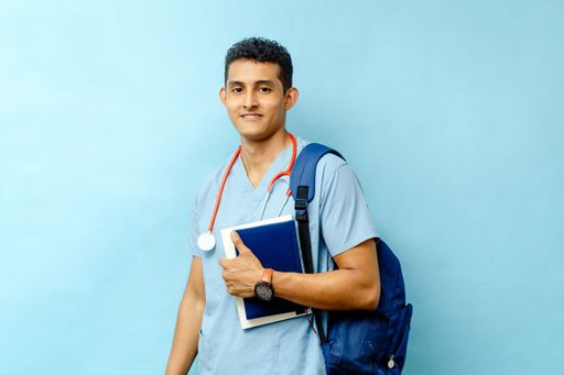 A young doctor wearing a medical uniform and stethoscope stands with a notebook in hand and a backpack