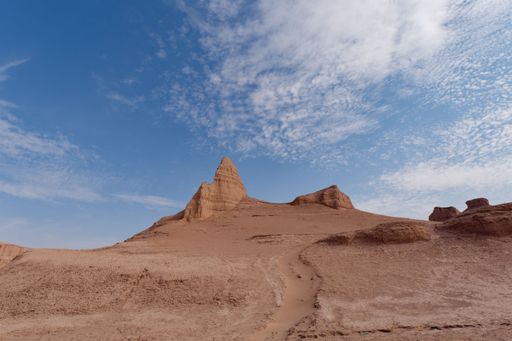 A breathtaking desert landscape featuring tall, red-hued rock formations against a bright blue sky