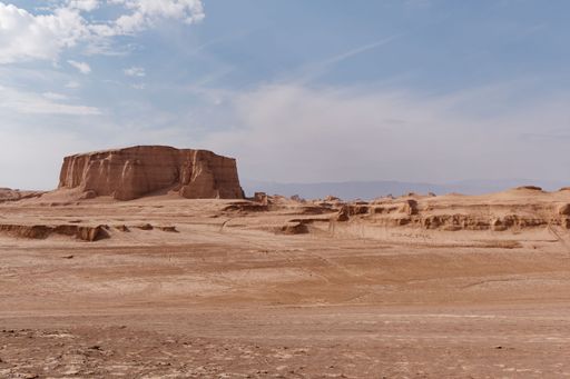 A breathtaking desert landscape featuring tall, red-hued rock formations against a bright blue sky