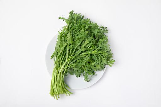 A top view of a bunch of fresh chinese mugwort on the plate isolated on white background
