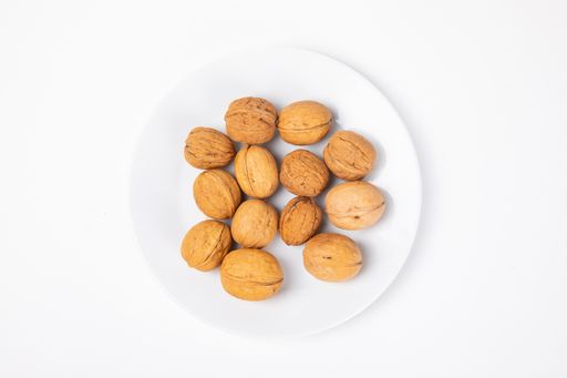 A top view of walnuts on the plate isolated on white background