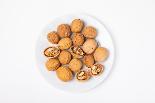 A top view of walnuts on the plate isolated on white background