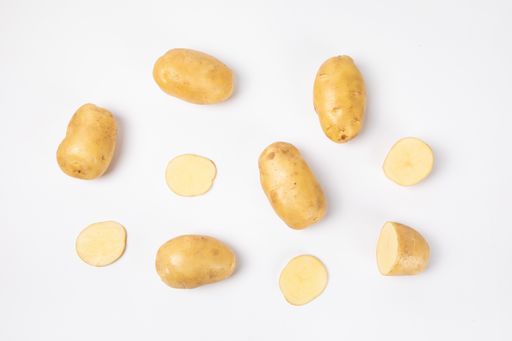 A top view of raw potatoes and cut pieces isolated on white background