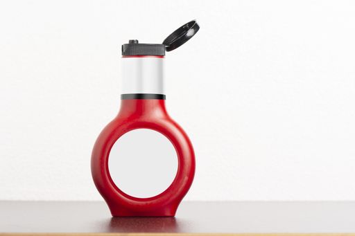 A tomato sauce bottle with an open lid on a black table, editable mock-up series template ready for your design