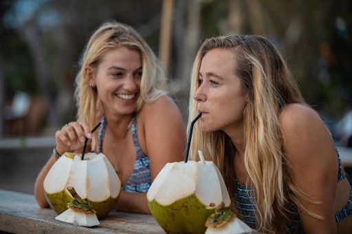 A closeup shot of two blonde women drinking next to each other having fun