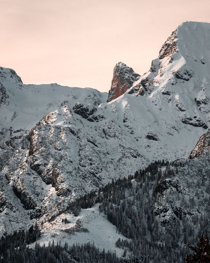 The new snow in austria covered the mountains in a layer of white, captured at golden hour with sunset light.