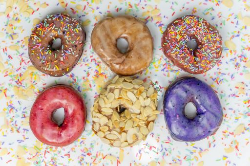 A close-up of assorted donuts arranged in a decorative fashion on a paper towel background