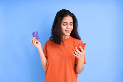 Latin woman with phone and credit card - the concept of online shopping