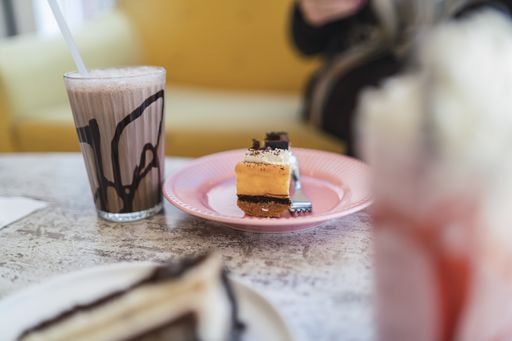 A closeup shot of chocolate and strawberry milkshakes and dessert on a table